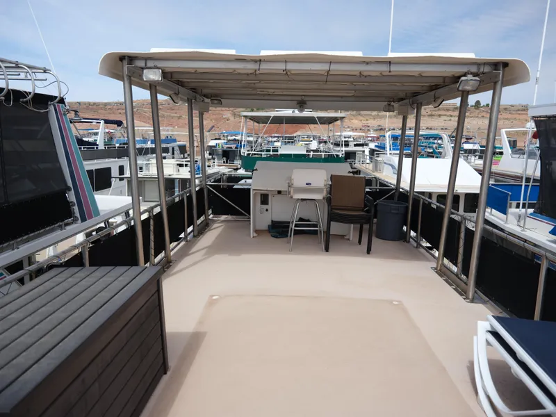 Slide: The Image of Top deck of a 1999 Custom 55x14 Stainless Houseboat with covered seating area. - 18