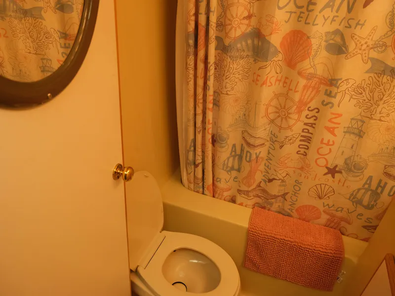 Slide: The Image of Bathroom in 1999 Custom 55x14 Stainless Houseboat with nautical-themed shower curtain. - 28