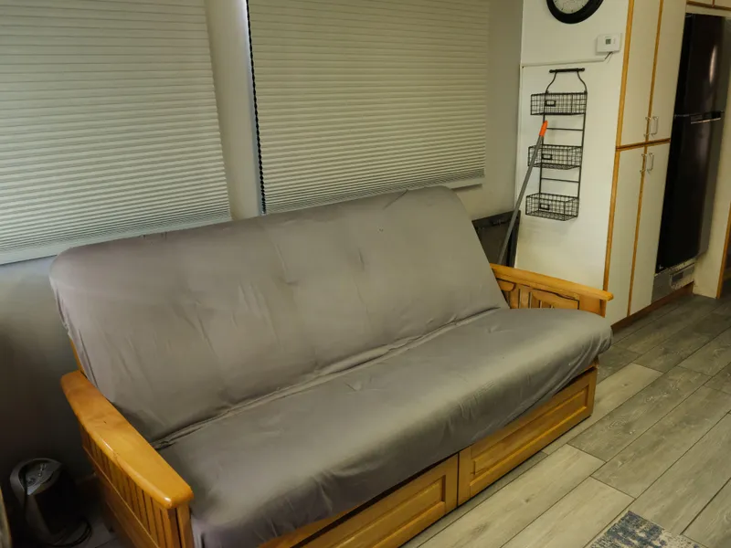 Slide: The Image of Interior of a 1999 Custom 55x14 Stainless Houseboat with a futon and modern decor. - 39