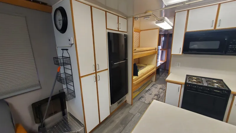 Slide: The Image of Interior of a 1999 Custom 55x14 Stainless Houseboat with kitchen and bunk beds. - 8