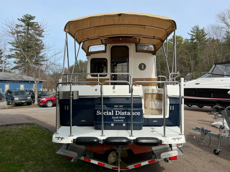 Slide: The Image of 2013 Ranger Tugs R-27 boat named "Social Distance" docked outdoors. - 13