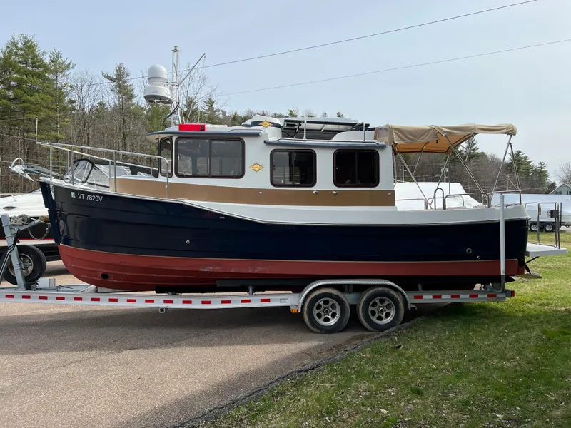 Slide: The Image of 2013 Ranger Tugs R-27 boat on trailer, parked outdoors. - 15