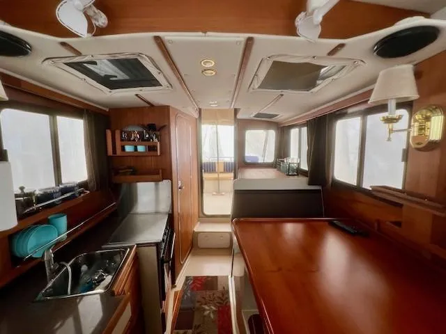Slide: The Image of Interior of 2013 Ranger Tugs R-27 boat, featuring kitchen and dining area. - 2
