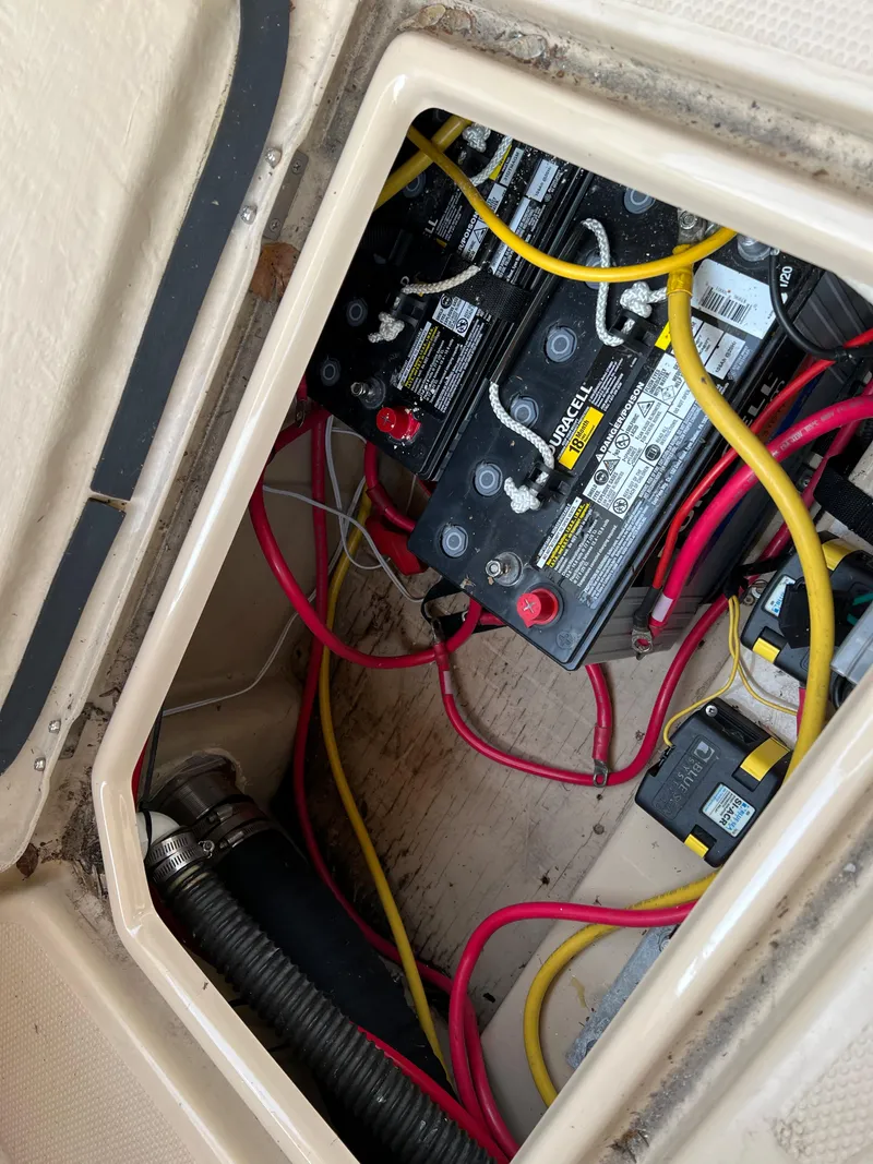 Slide: The Image of 2013 Ranger Tugs R-27 battery compartment with wiring and connections. - 28