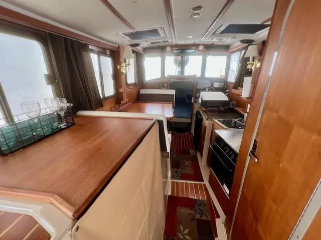 Slide: The Image of Interior of 2013 Ranger Tugs R-27 boat, featuring kitchen and seating area. - 3