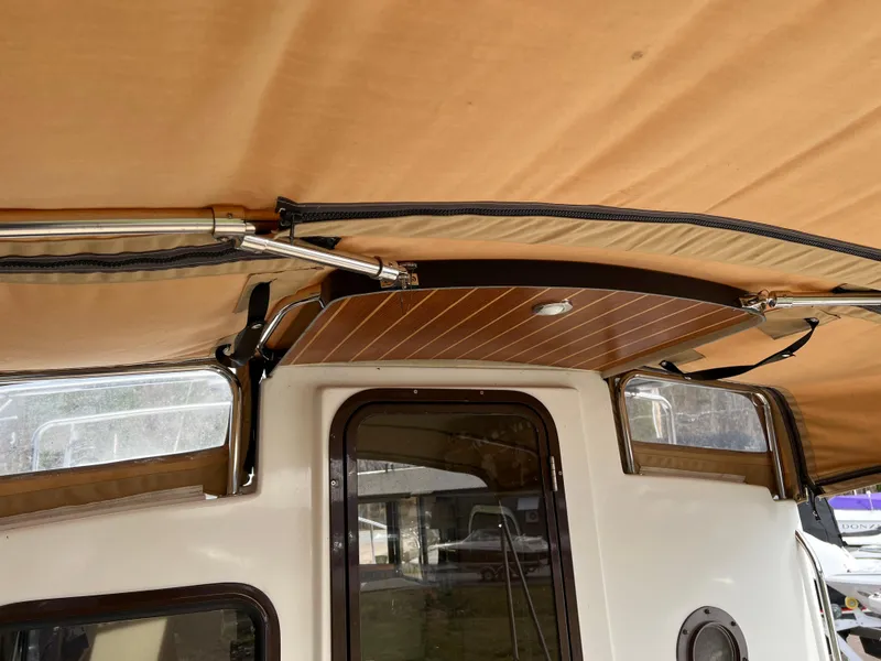 Slide: The Image of Interior view of 2013 Ranger Tugs R-27 boat with tan canopy and wood accents. - 32