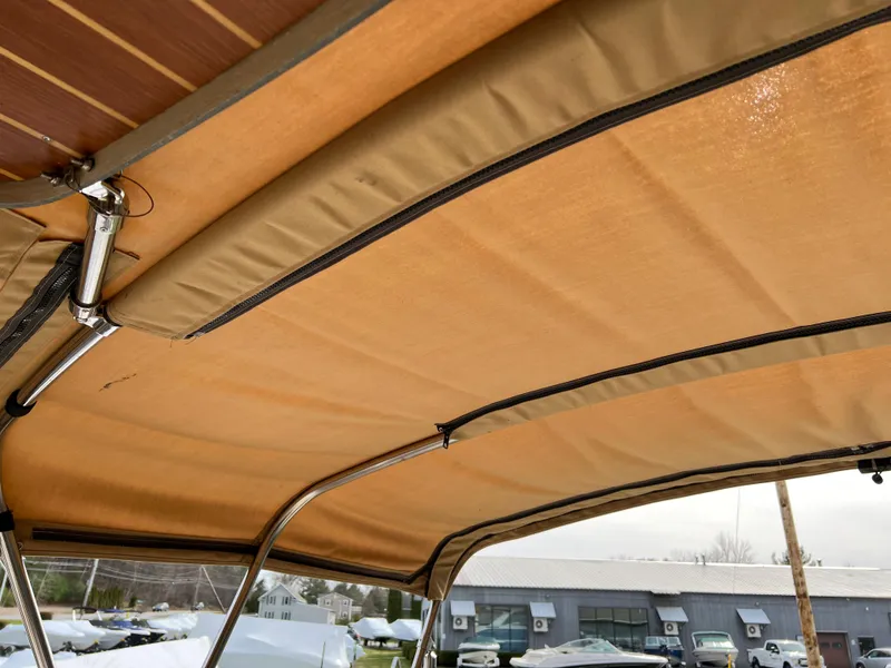 Slide: The Image of 2013 Ranger Tugs R-27 boat canopy with metal frame, outdoor setting. - 33
