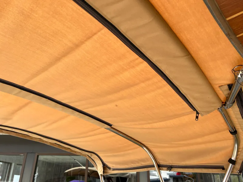 Slide: The Image of Tan canopy of 2013 Ranger Tugs R-27 boat with metal support frame. - 34