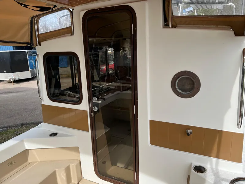 Slide: The Image of 2013 Ranger Tugs R-27 boat exterior with glass door and porthole. - 35