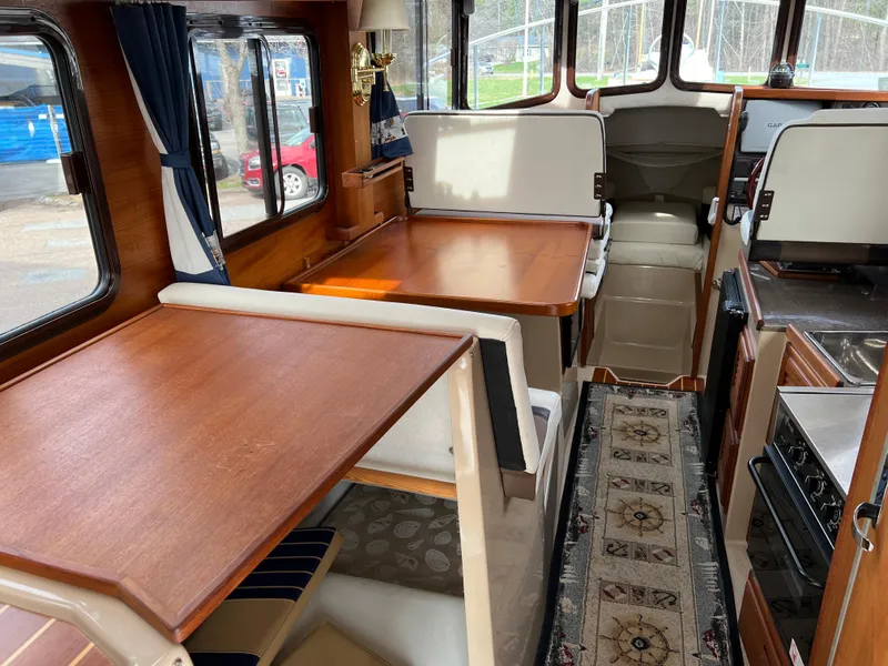 Slide: The Image of Interior of 2013 Ranger Tugs R-27 boat with wood furnishings and seating area. - 36