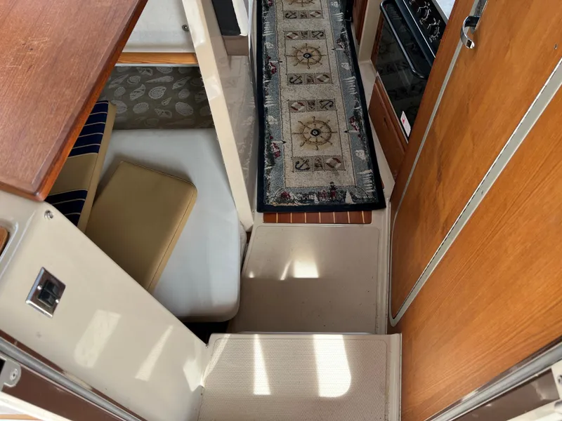 Slide: The Image of Interior of 2013 Ranger Tugs R-27 boat with carpeted steps and wooden cabinetry. - 37