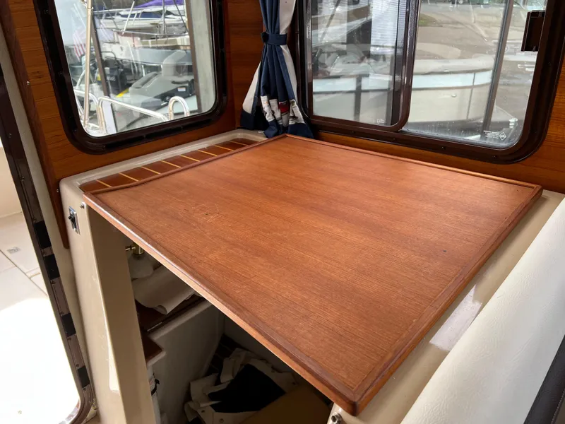 Slide: The Image of Interior of 2013 Ranger Tugs R-27 with wooden table and window view. - 41