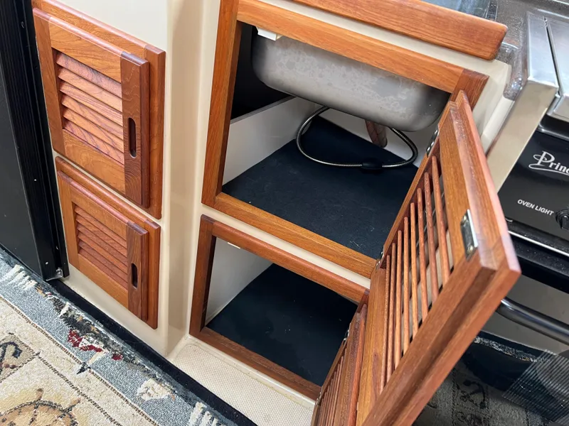 Slide: The Image of 2013 Ranger Tugs R-27 interior with open wooden cabinet doors. - 46