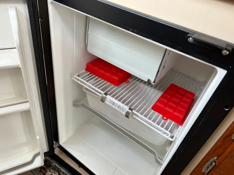 Slide: The Image of Open refrigerator in 2013 Ranger Tugs R-27 boat with red ice trays. - 47