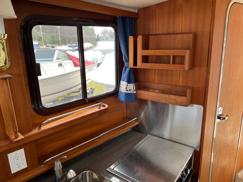 Slide: The Image of Interior of 2013 Ranger Tugs R-27 boat with wooden cabinetry and window view. - 48