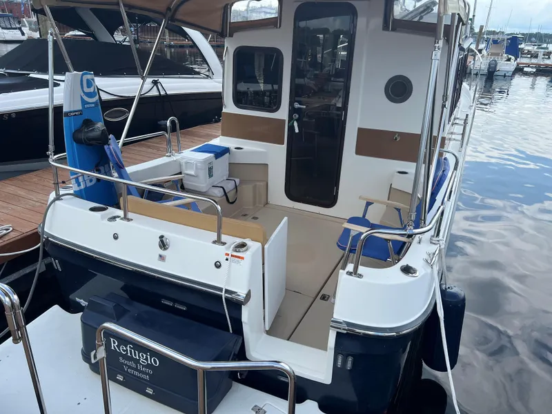 Slide: The Image of 2013 Ranger Tugs R-27 boat docked, featuring spacious deck and seating area. - 5