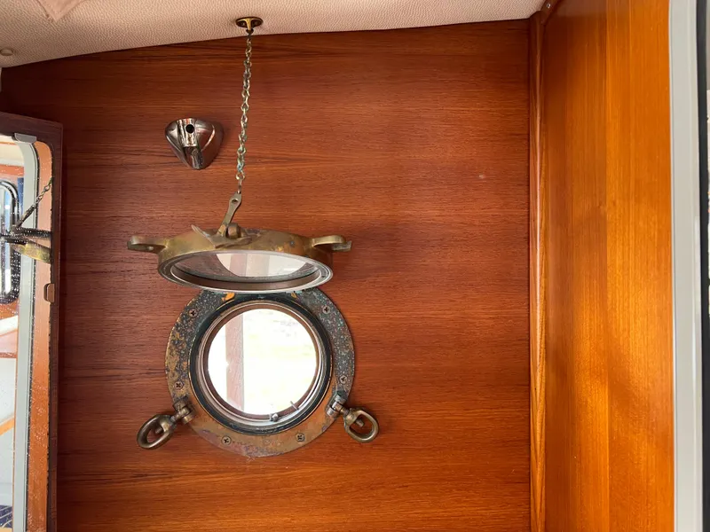 Slide: The Image of 2013 Ranger Tugs R-27 interior with wooden paneling and open porthole. - 53