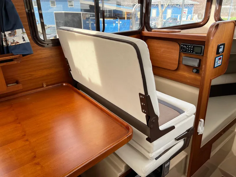 Slide: The Image of Interior of 2013 Ranger Tugs R-27 with wooden table and cushioned seating. - 57