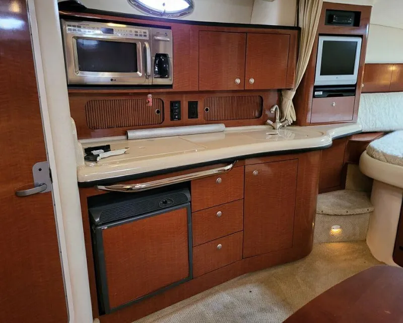 Slide: The Image of 2005 Sea Ray 320 Sundancer galley with microwave, fridge, and TV. - 20