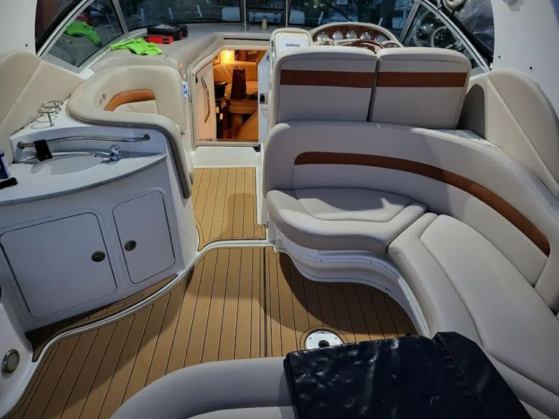 Slide: The Image of Interior of 2005 Sea Ray 320 Sundancer boat with beige seating and wooden flooring. - 36