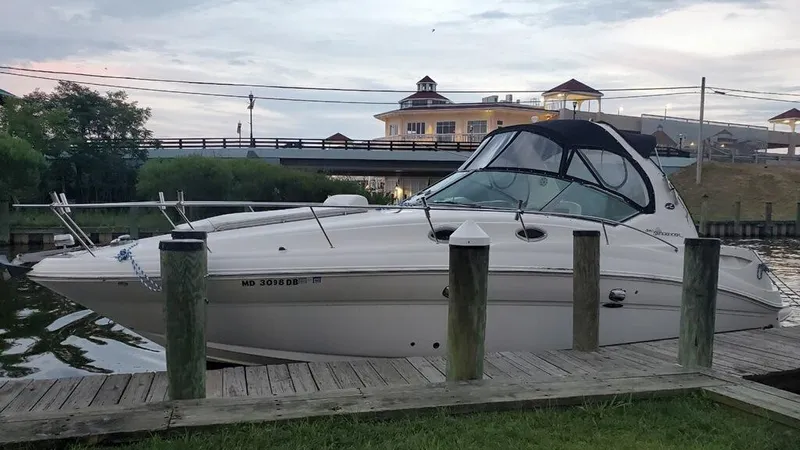 Slide: The Image of 2005 Sea Ray 320 Sundancer docked at a marina with a scenic background. - 4