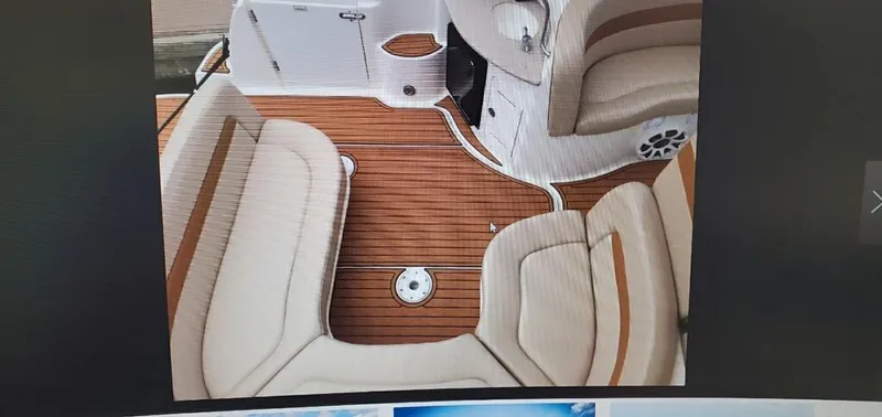 Slide: The Image of 2005 Sea Ray 320 Sundancer boat interior with beige seating and wooden flooring. - 8