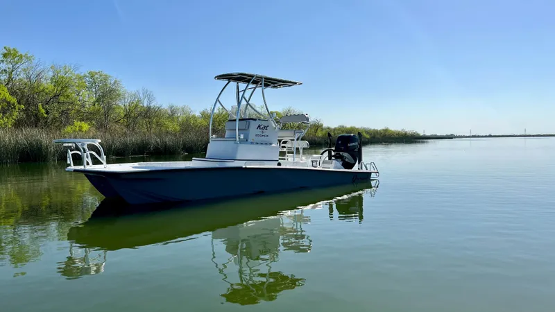Slide: The Image of 2023 Dargel KAT 250 DX boat on calm water with clear blue sky. - 31