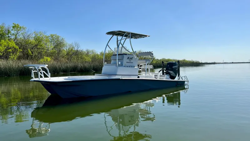 Slide: The Image of 2023 Dargel KAT 250 DX boat on calm water with trees in the background. - 33