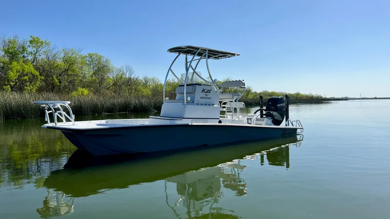 Slide: The Image of 2023 Dargel KAT 250 DX boat on calm water with clear blue sky. - 34