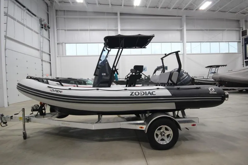 Slide: The Image of 2023 Zodiac Open 5.5 PVC T-Top 115hp boat on trailer in showroom. - 0