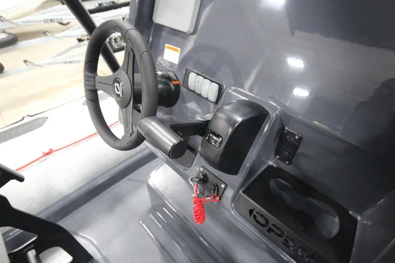 Slide: The Image of 2023 Zodiac Open 5.5 PVC T-Top 115hp boat console with steering wheel and controls. - 11