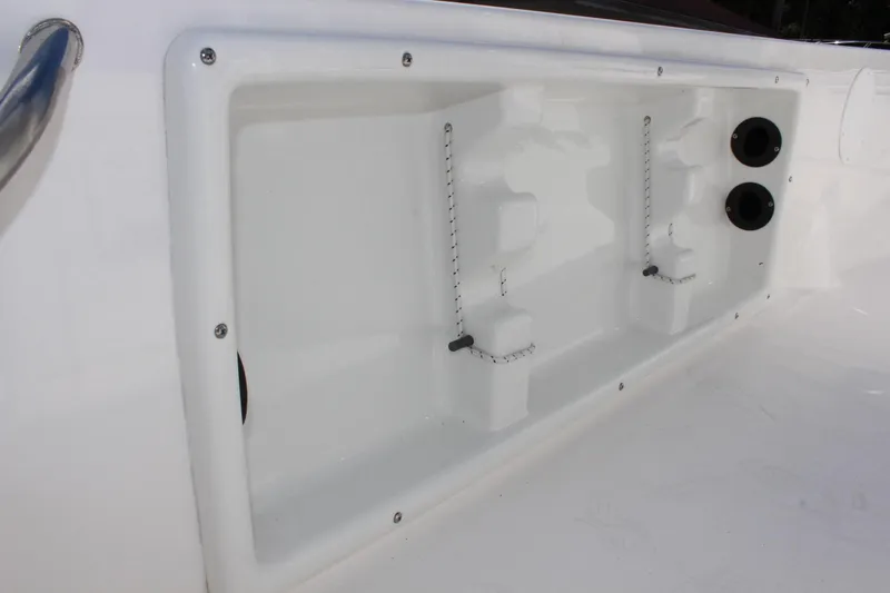 Slide: The Image of 2022 NauticStar 195 XTS boat storage compartment with secure holders and dual outlets. - 33