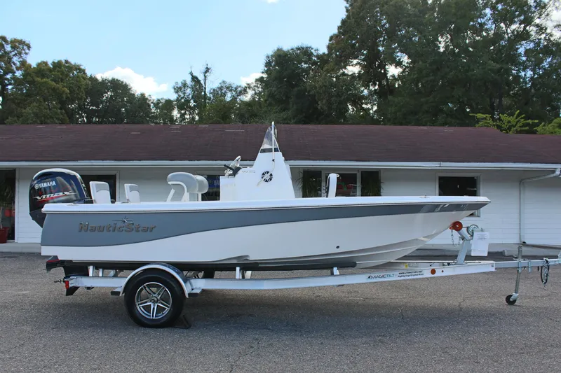 Slide: The Image of 2022 NauticStar 195 XTS boat on trailer, parked in front of a building. - 6