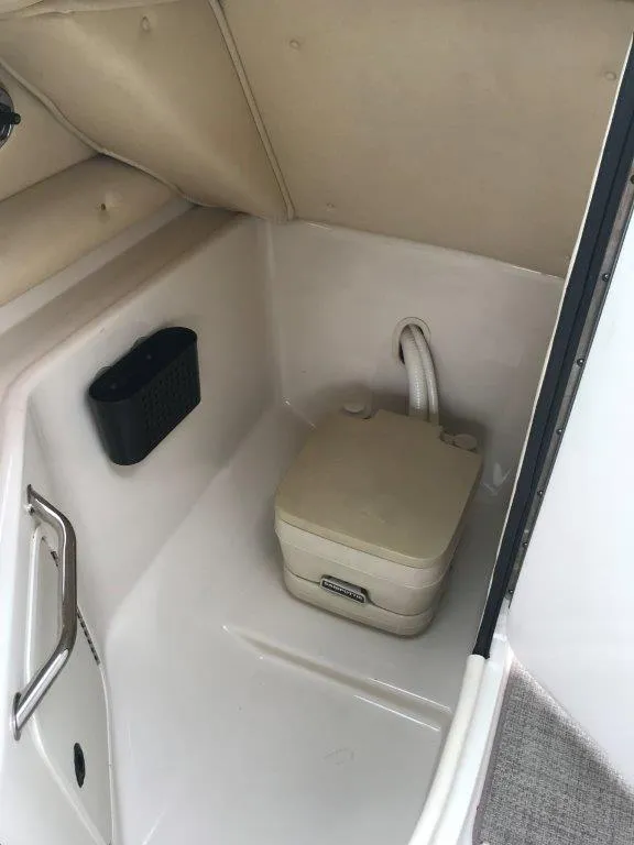 Slide: The Image of 2003 Sea Ray 240 Sundeck interior with portable toilet and storage compartment. - 11
