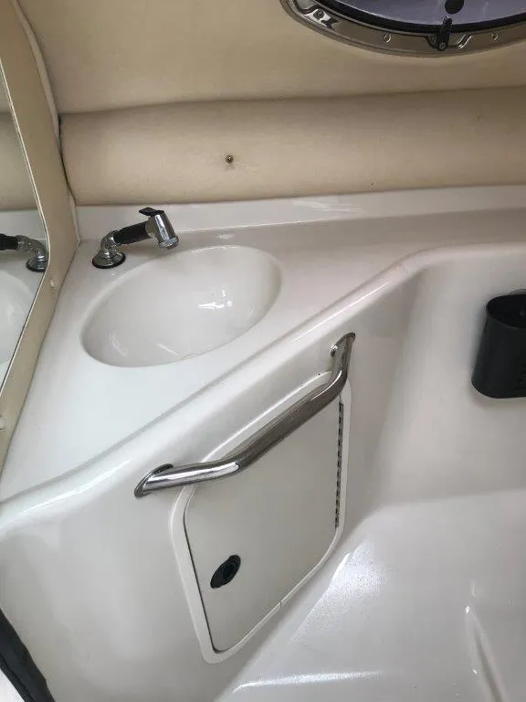 Slide: The Image of 2003 Sea Ray 240 Sundeck interior sink and storage compartment. - 12