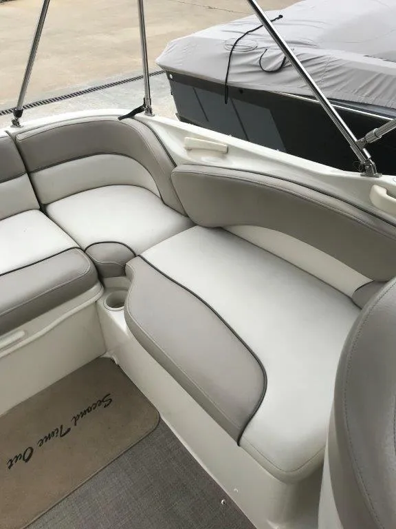 Slide: The Image of 2003 Sea Ray 240 Sundeck interior with cushioned seating and cup holder. - 14