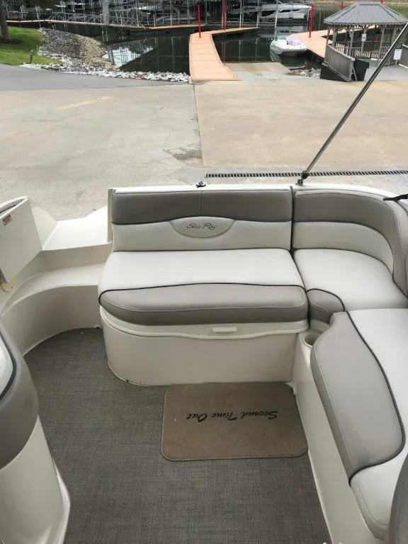 Slide: The Image of 2003 Sea Ray 240 Sundeck interior with gray seating and dock view. - 15