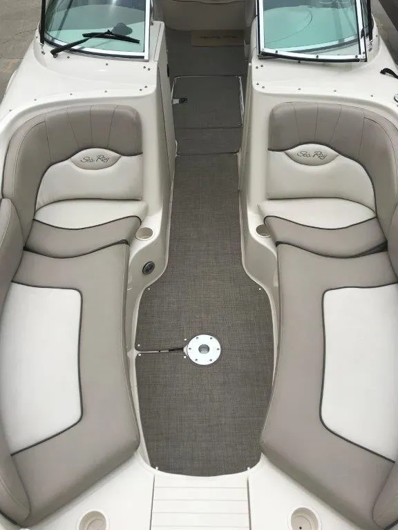 Slide: The Image of 2003 Sea Ray 240 Sundeck interior with beige seating and carpeted floor. - 2