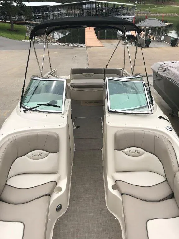Slide: The Image of 2003 Sea Ray 240 Sundeck boat interior with beige seating and black canopy. - 4