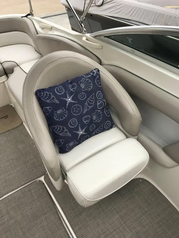 Slide: The Image of 2003 Sea Ray 240 Sundeck interior with seashell-patterned cushion on white seat. - 9