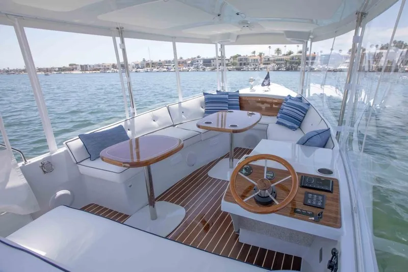 Slide: The Image of 2025 Duffy Sun Cruiser interior with seating, tables, and steering wheel on calm water. - 3