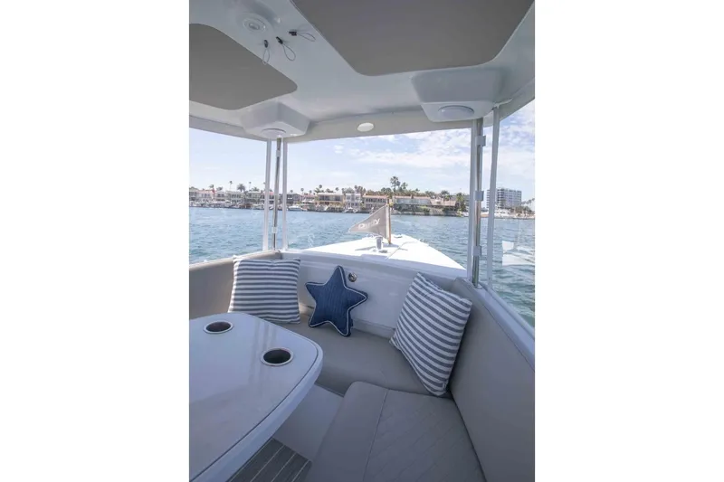 Slide: The Image of 2025 Duffy Sun Cruiser interior with striped cushions, star pillow, and waterfront view. - 4
