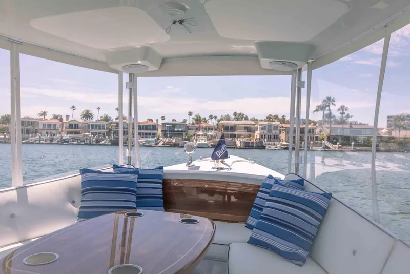 Slide: The Image of Interior view of 2025 Duffy Sun Cruiser boat with striped cushions and waterfront houses. - 5