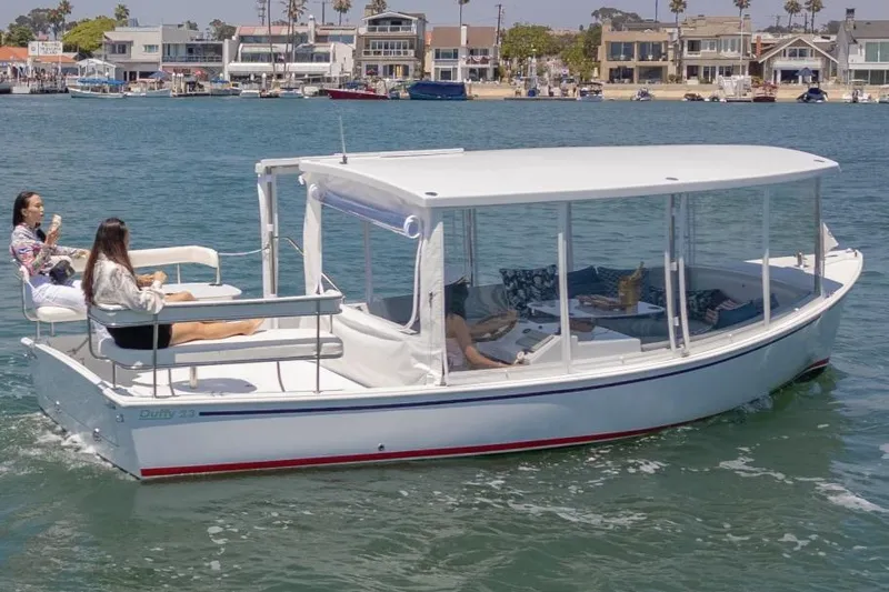 Slide: The Image of 2025 Duffy Sun Cruiser boat on water with people relaxing, coastal homes in background. - 7