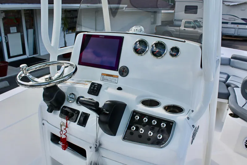 Slide: The Image of 2023 NauticStar 231 Hybrid boat dashboard with steering wheel and control panel. - 17