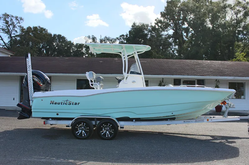 Slide: The Image of 2023 NauticStar 231 Hybrid boat on trailer, parked outdoors. - 3