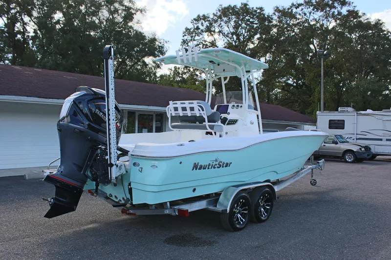Slide: The Image of 2023 NauticStar 231 Hybrid boat on trailer, parked outdoors. - 4