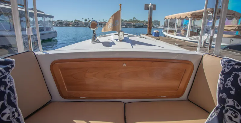 Slide: The Image of 2026 Duffy Bay Island boat interior with cushioned seating and wooden paneling, docked at marina. - 6
