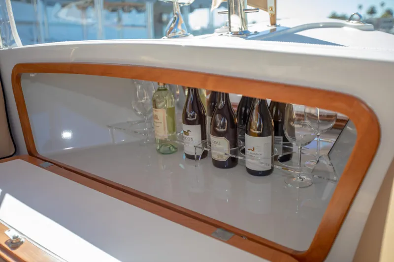 Slide: The Image of 2026 Duffy Bay Island boat with wine bottles and glasses in a wooden cabinet. - 7
