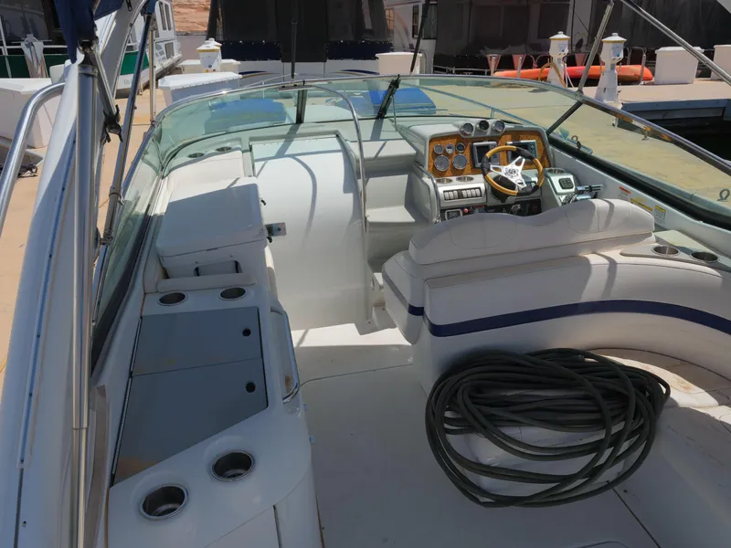 Slide: The Image of 2012 Formula 310 Sun Sport boat interior with helm, seating, and docked at marina. - 13